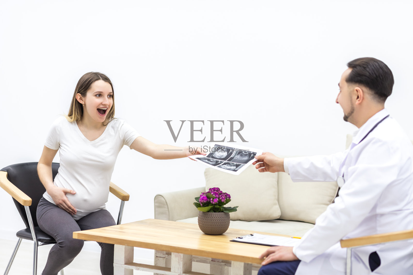 身穿白大褂的医生给病人做超声检查的照片。照片摄影图片