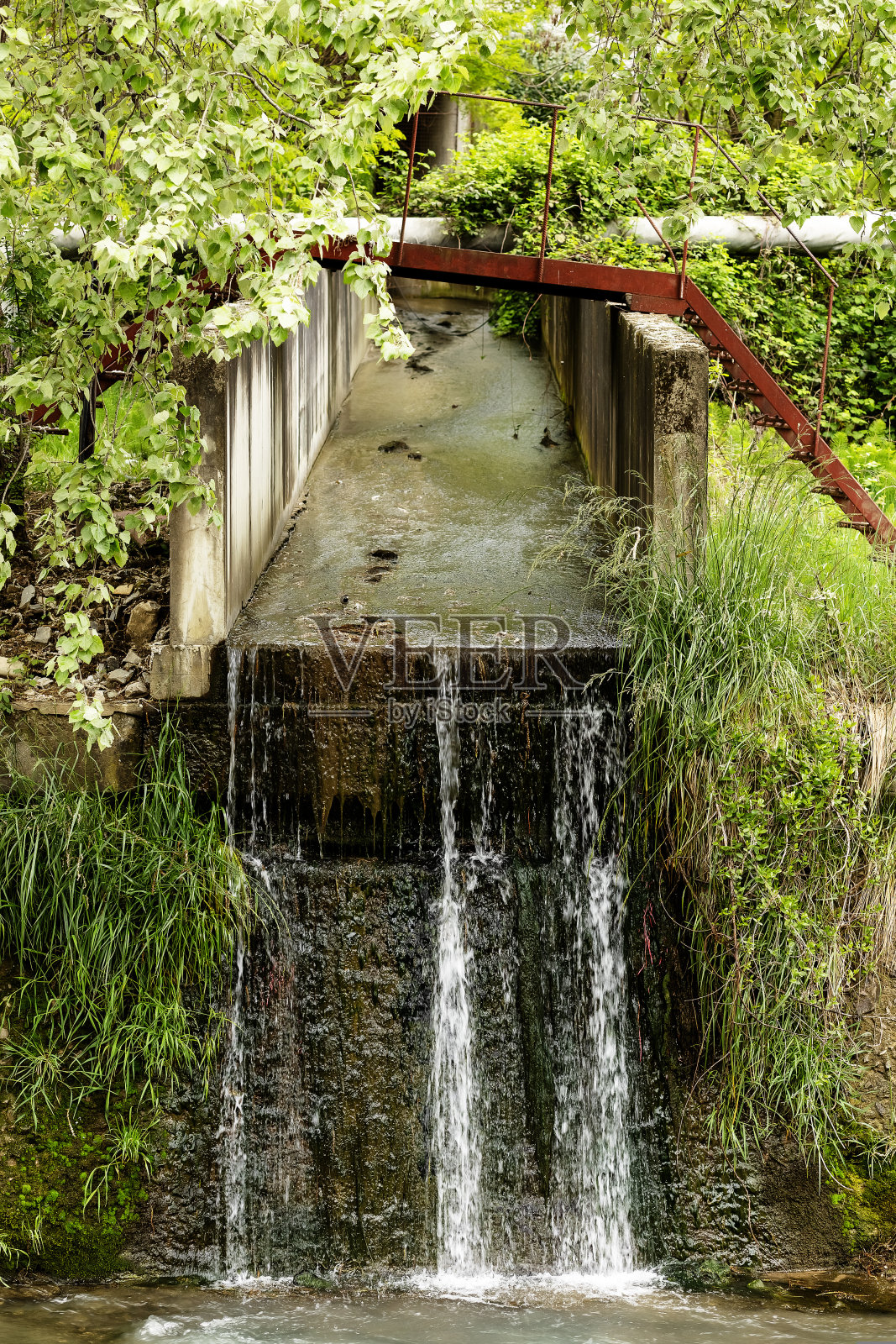 水顺着混凝土排水管流入河流照片摄影图片