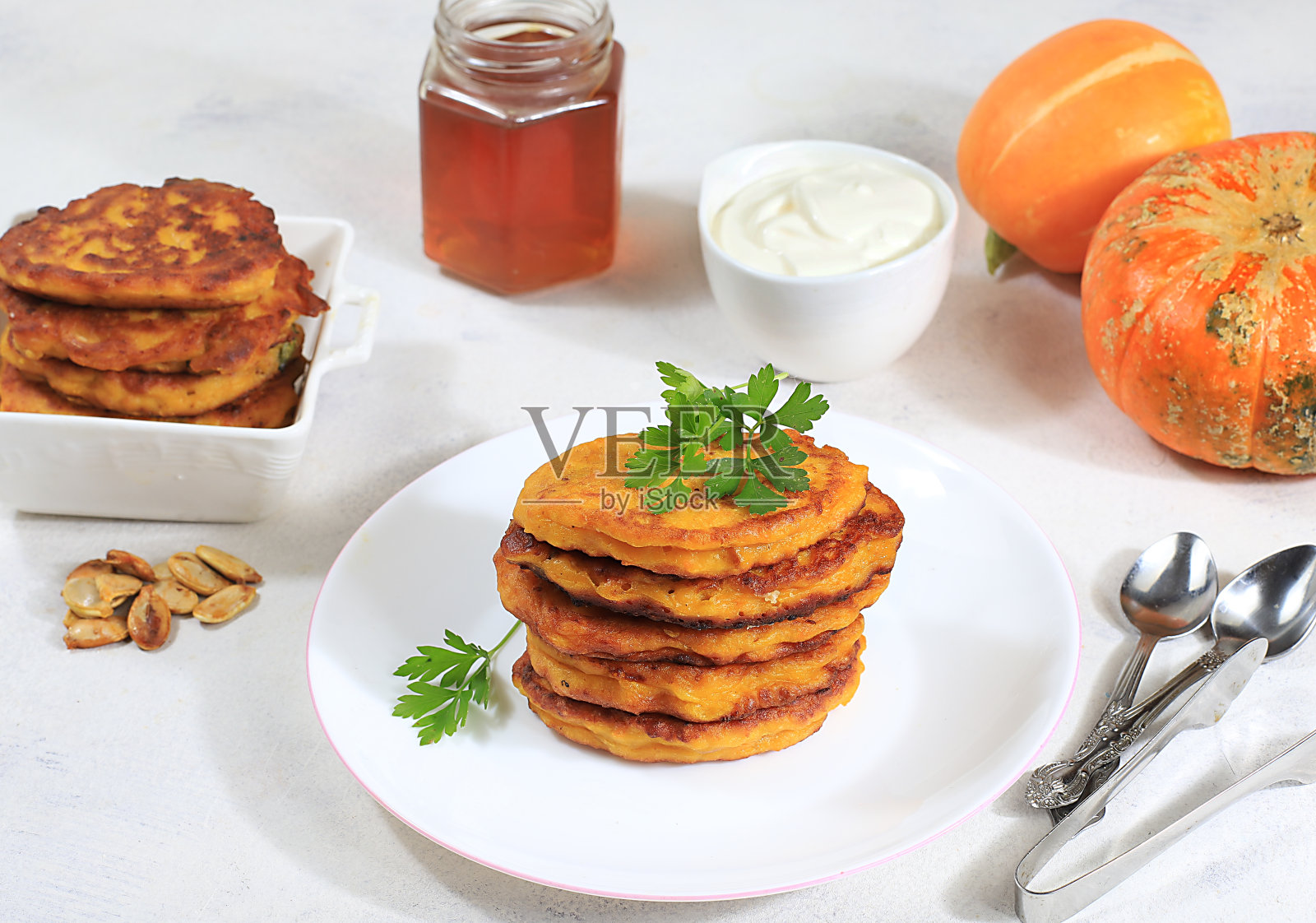 美味的俄罗斯南瓜煎饼，配酸奶油和蜂蜜。传统的秋季减肥早餐照片摄影图片