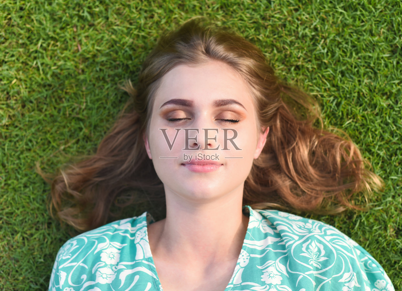 美丽的白俄罗斯妇女睡觉，躺在草地上闭着眼睛照片摄影图片