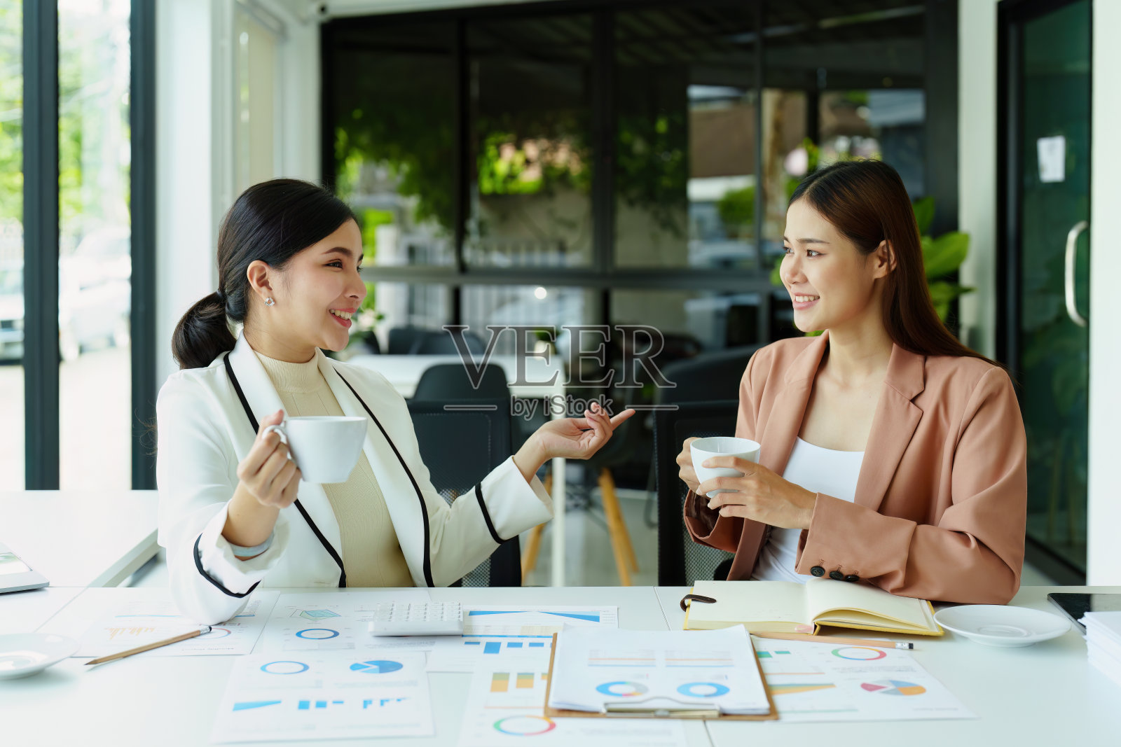 营销和销售的女员工一边聊天一边喝咖啡休息。照片摄影图片