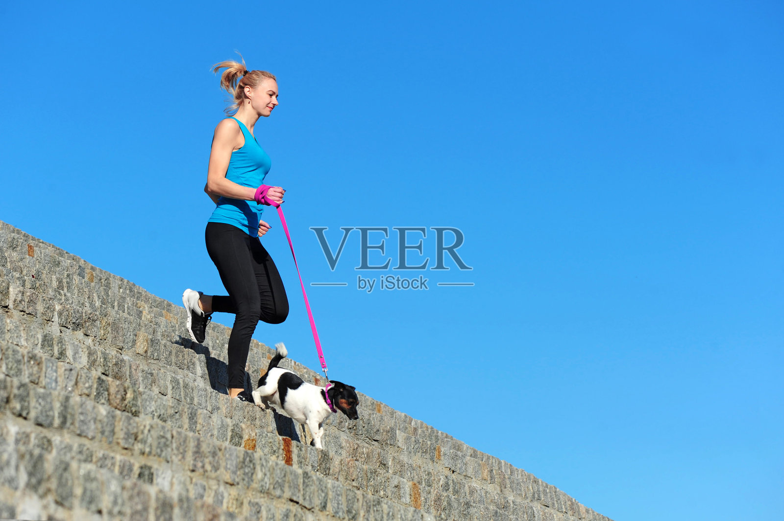 运动的女人带着她的狗跑下楼梯照片摄影图片