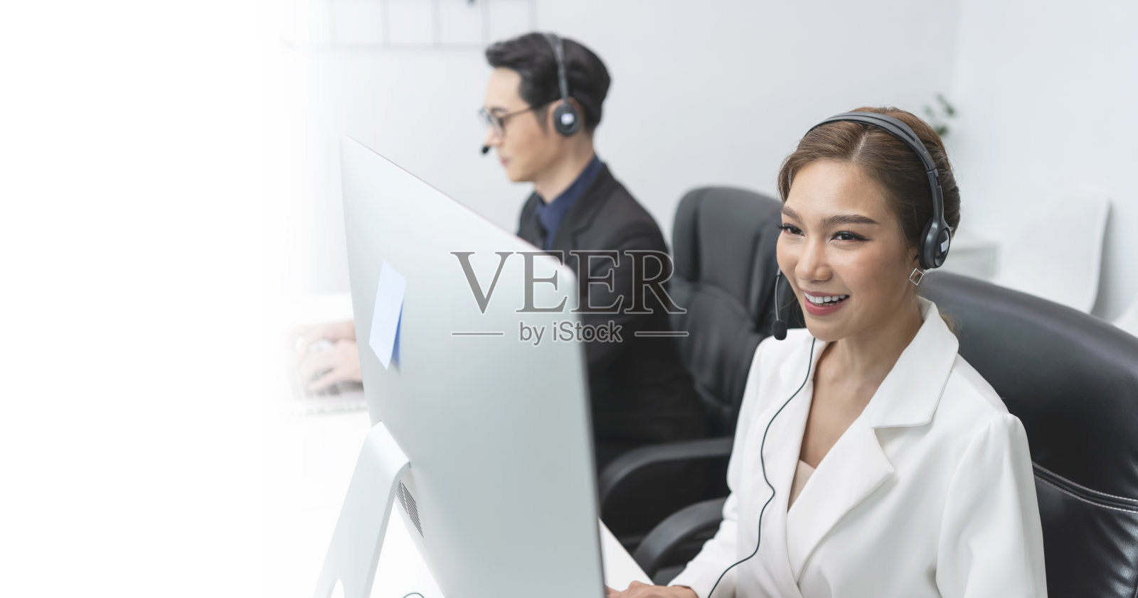 亚洲呼叫中心座席团队，客户服务支持，戴着耳机或耳机在现代化的办公室与客户交谈。照片摄影图片