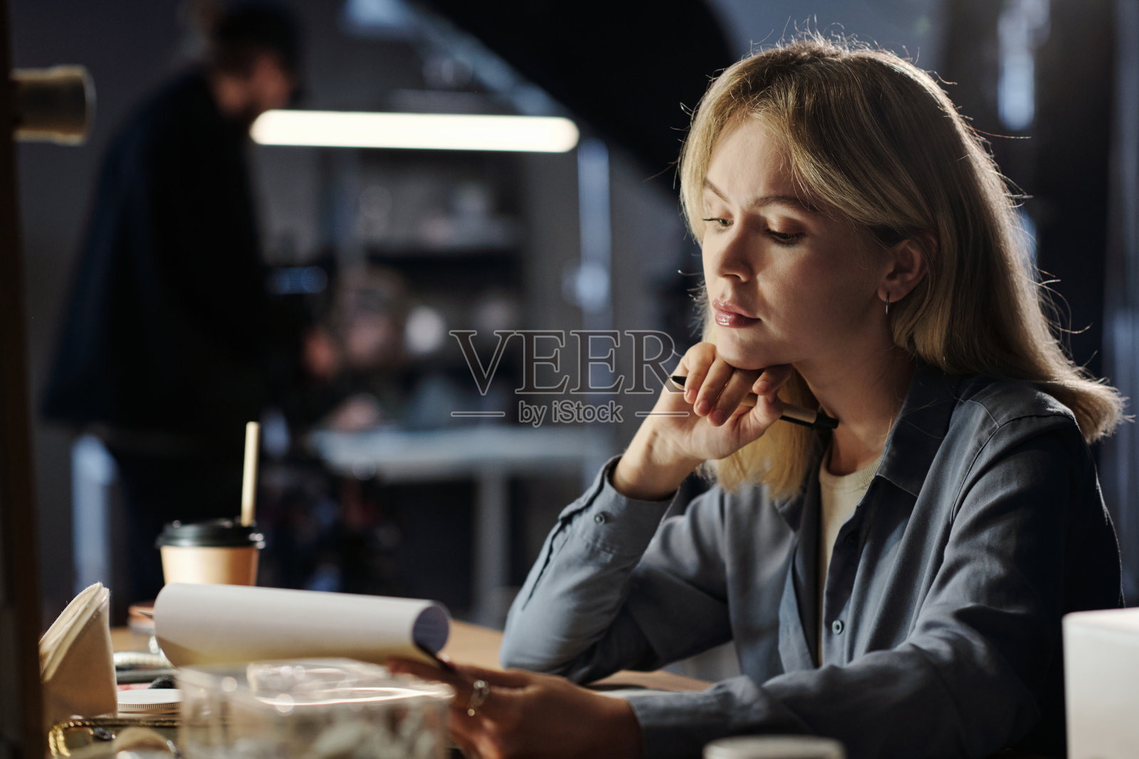 年轻严肃的金发女人专注于阅读文件中的信息照片摄影图片