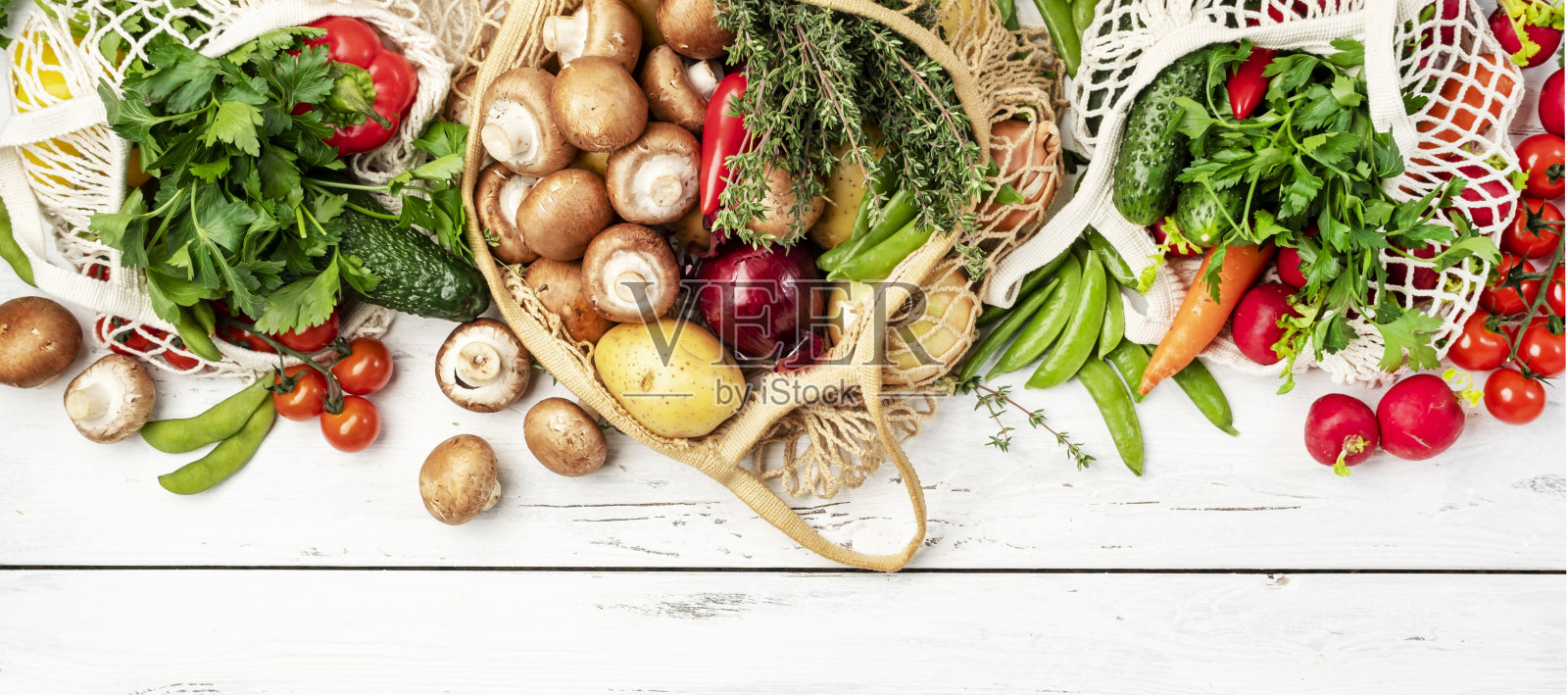 健康食物:蘑菇、豆类、番茄、牛油果和草药。可重复使用的购物纺织袋装满了当地农贸市场的有机春季蔬菜。前视图。可持续的零浪费生活方式理念照片摄影图片