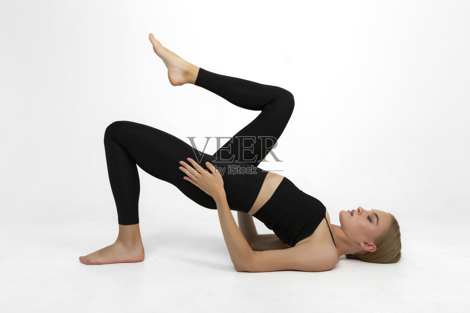 年轻的运动女士做伸展动作。照片摄影图片