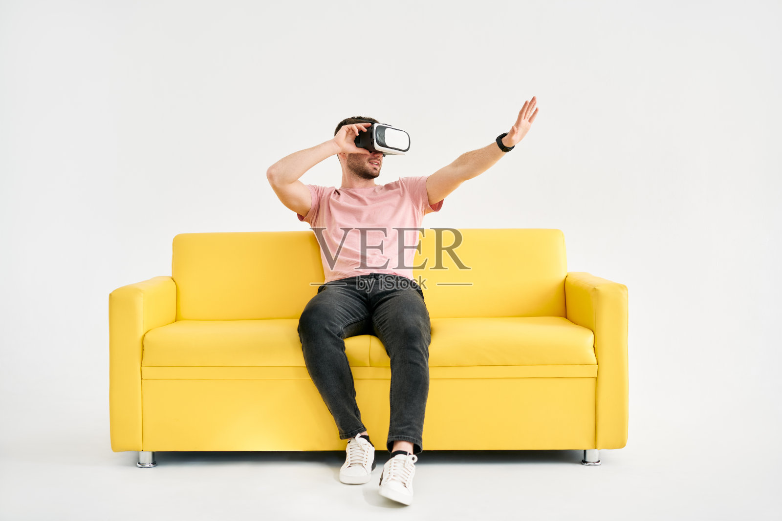 年轻人戴着虚拟现实头盔玩电子游戏，试图用手触摸东西照片摄影图片