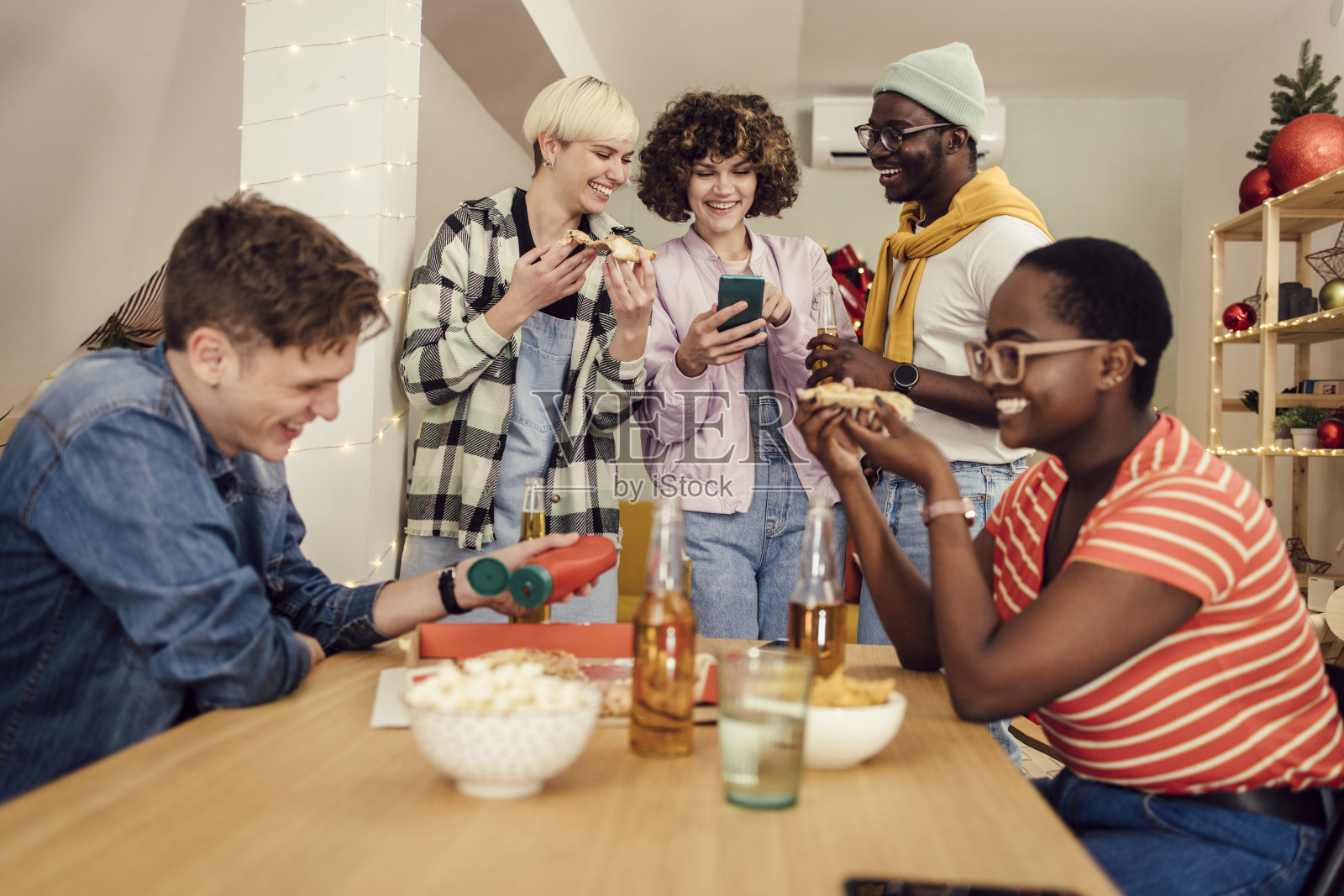 一群青少年使用智能手机，享受他们的家庭除夕夜派对照片摄影图片