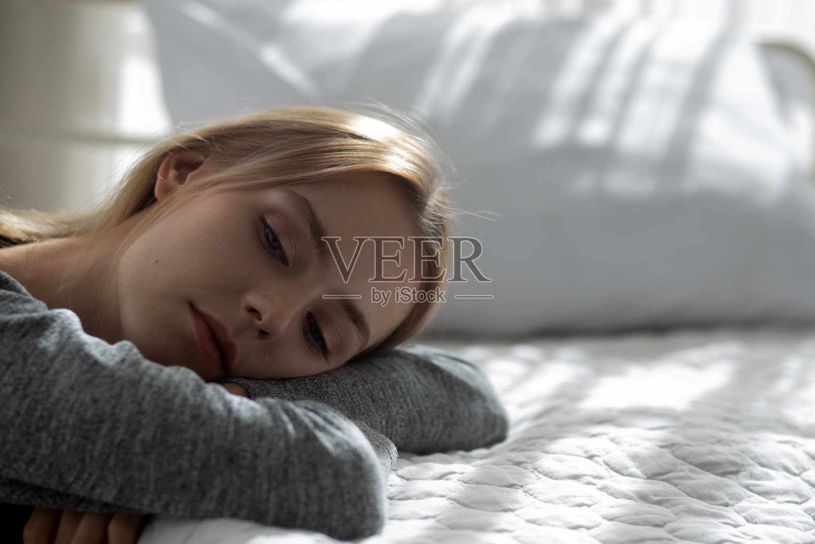 在卧室里有抑郁症和精神问题的年轻白人女性，情绪消极，女人孤独，担心，失望，表情和绝望，生活方式概念照片摄影图片