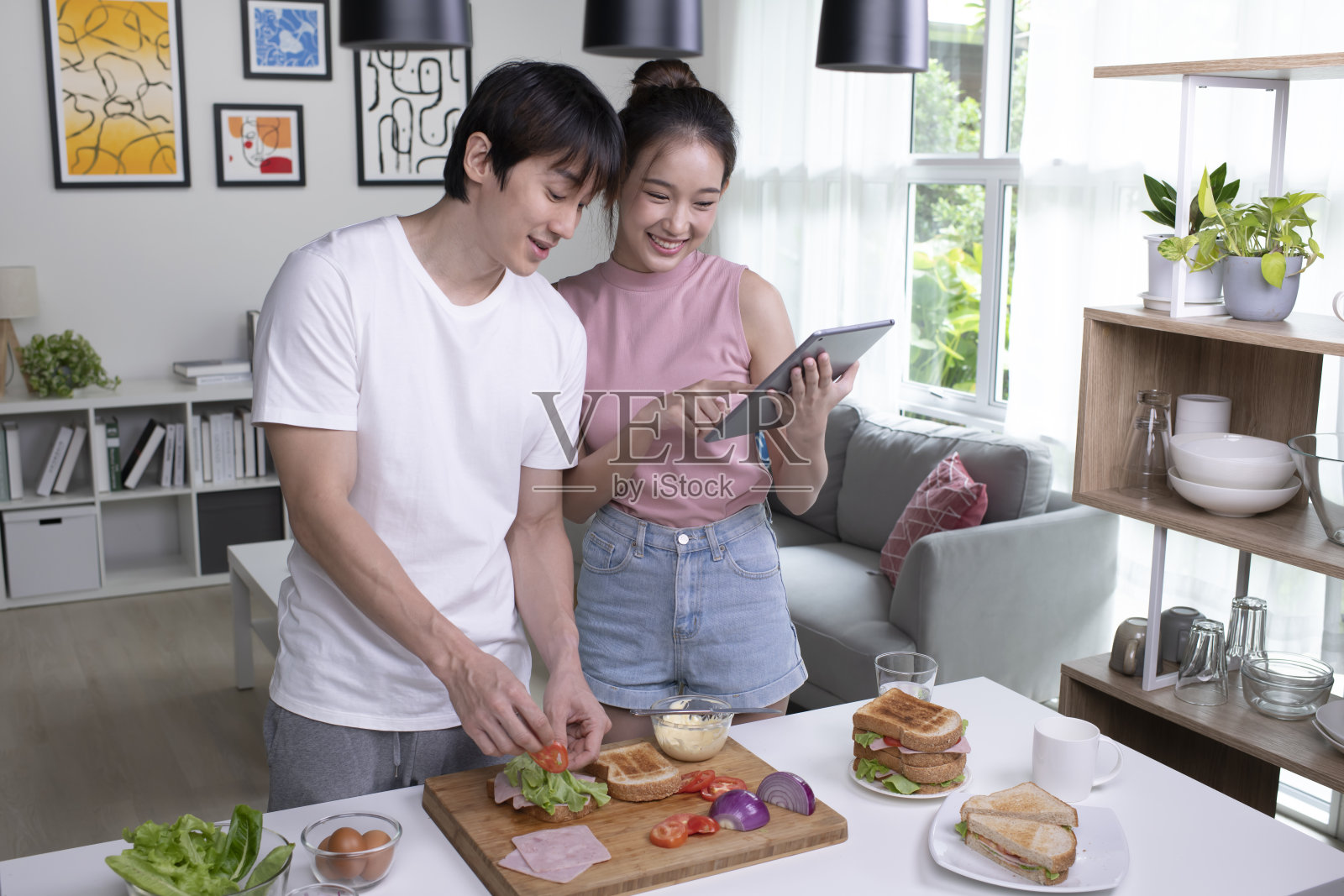 一对亚洲夫妇正在家里的厨房里做饭。照片摄影图片