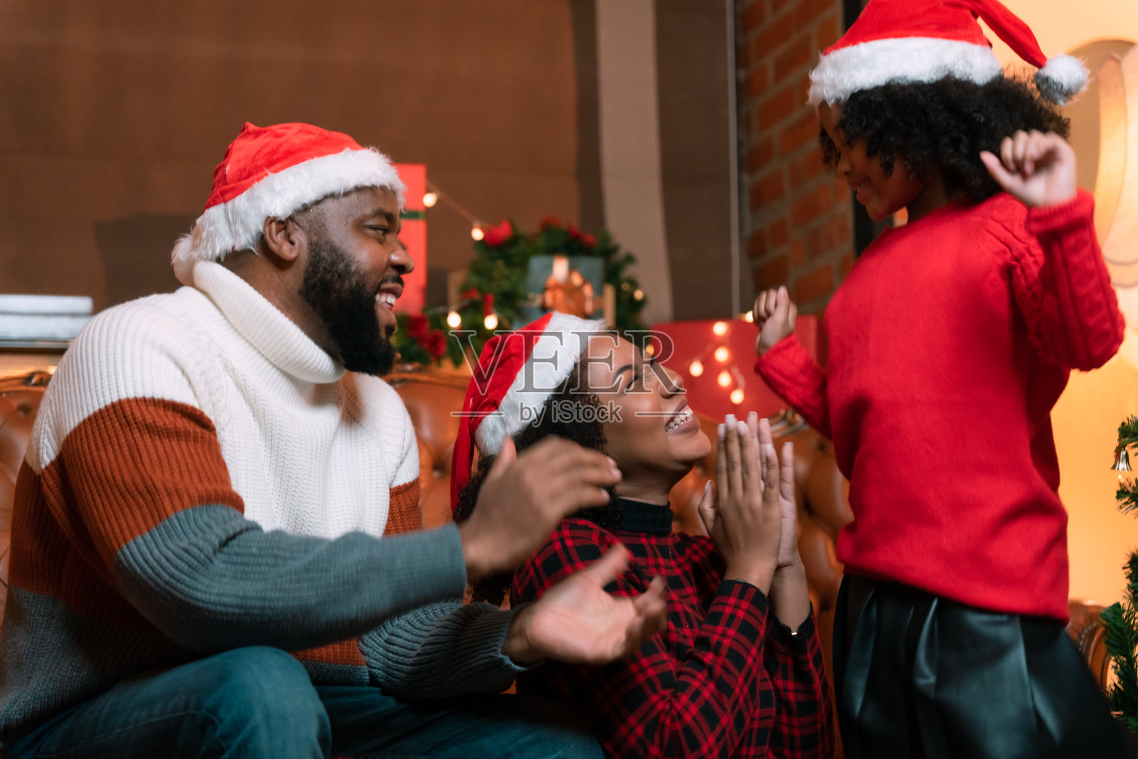 家人、爸爸、妈妈和孩子们正在高兴地装饰家里的圣诞树。照片摄影图片