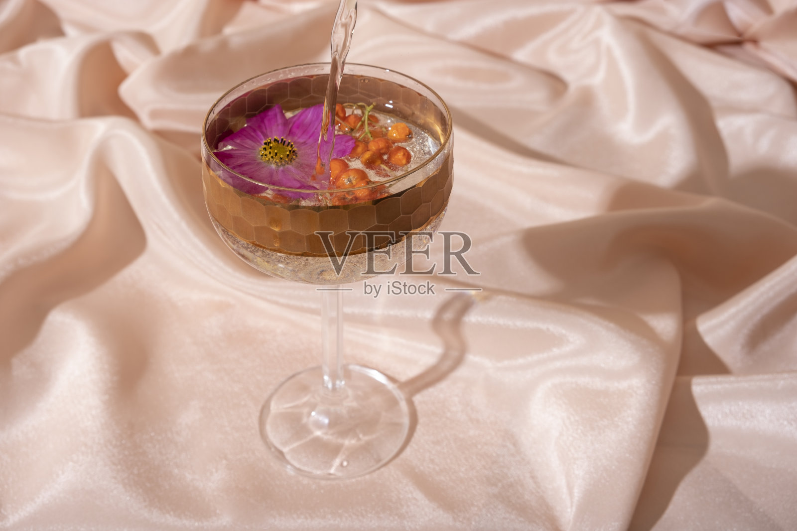 静物从玻璃和水与山灰和花折叠织物背景。极简创意的夏秋概念照片摄影图片