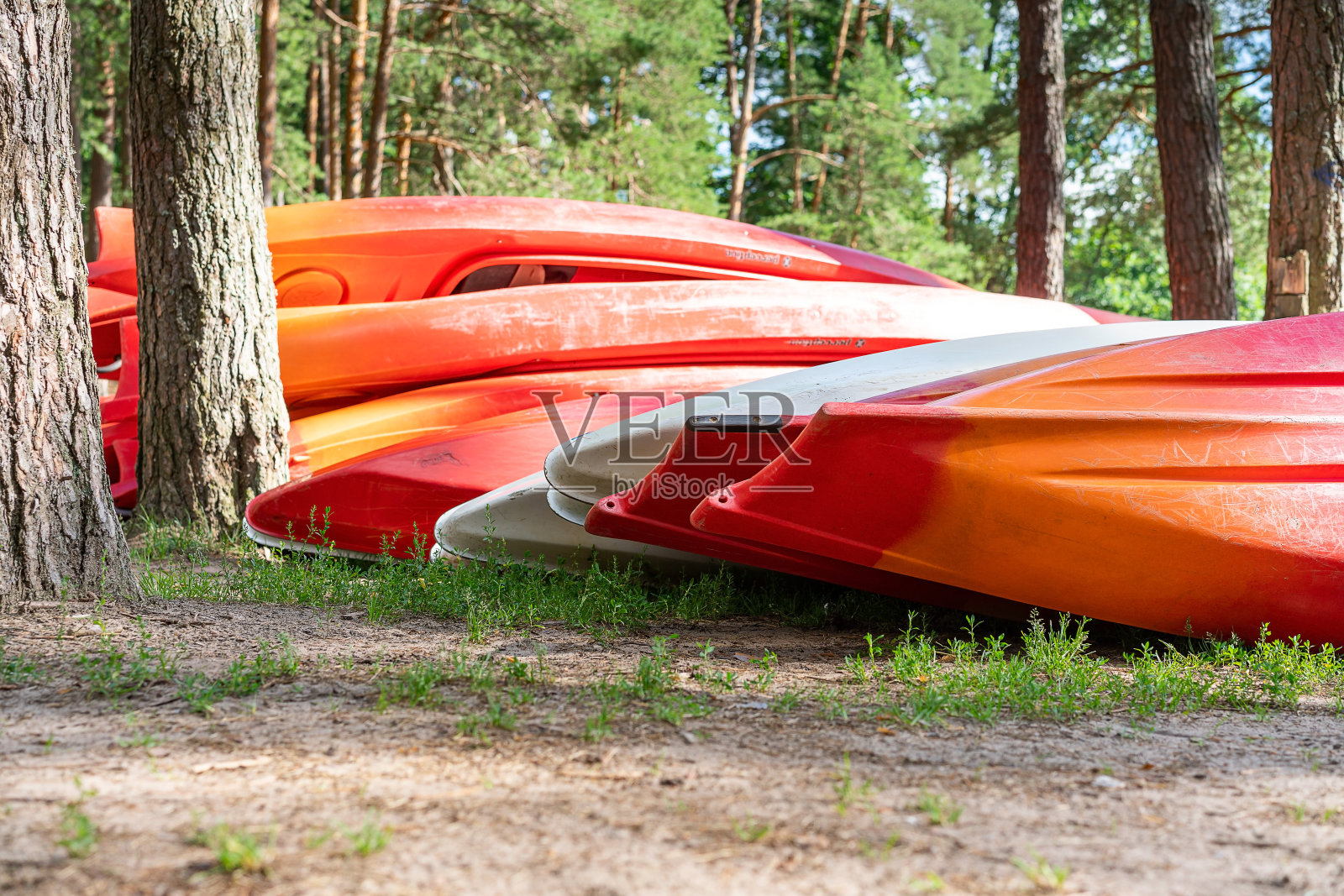 塑料皮艇在经过一次极端的顺流而下后被堆放在树林里。户外休闲，健康生活方式，户外娱乐照片摄影图片