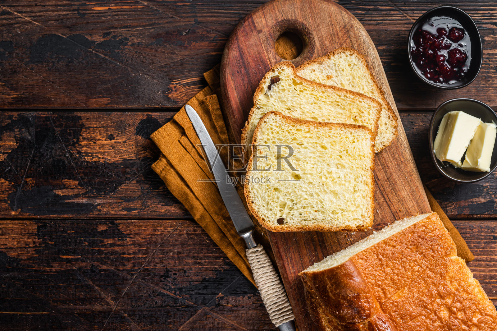 早餐桌上有奶油和果酱的布里欧什面包。木制背景。前视图。本空间照片摄影图片