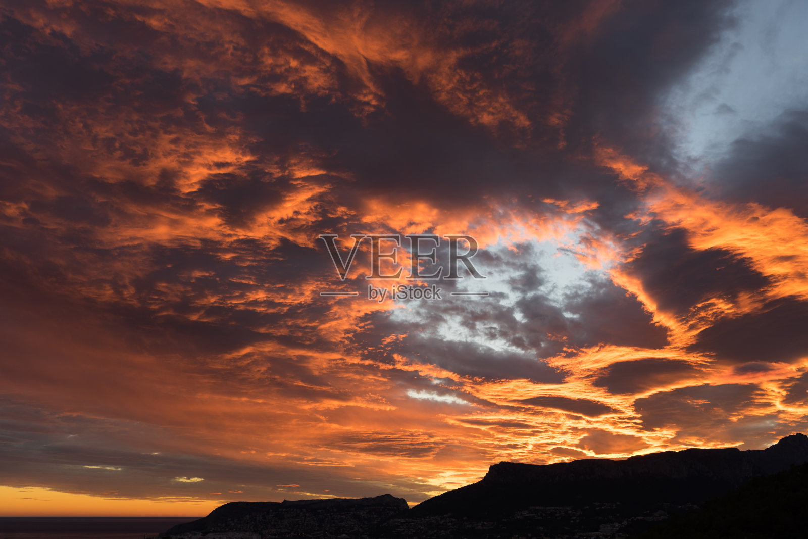 日落时发光的橙色云景和海岸景观照片摄影图片