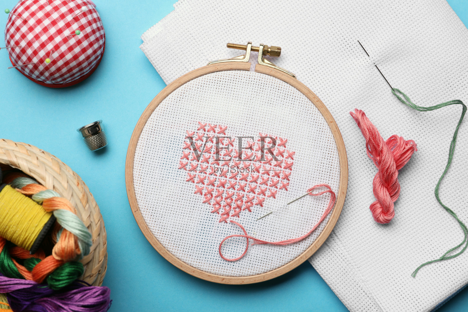 平铺构图与刺绣和不同的缝纫配件在浅蓝色的背景照片摄影图片