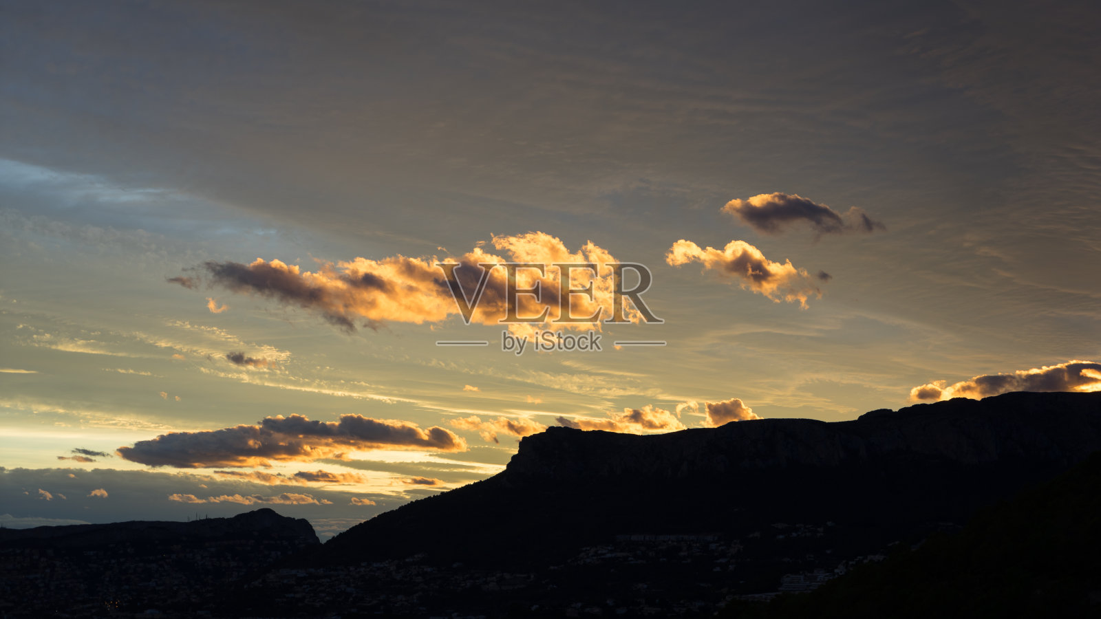 地中海海岸日落时的金色云景照片摄影图片