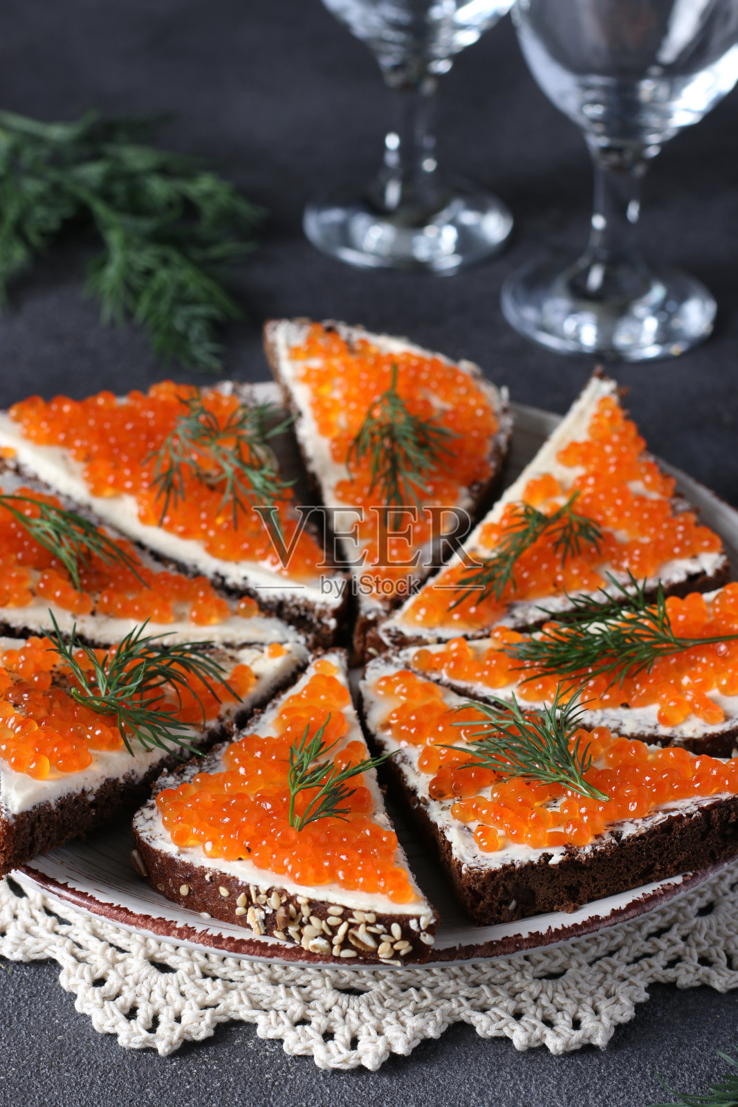 自制三明治，黑麦面包配红鱼子酱，灰色背景的盘子，节日小吃照片摄影图片