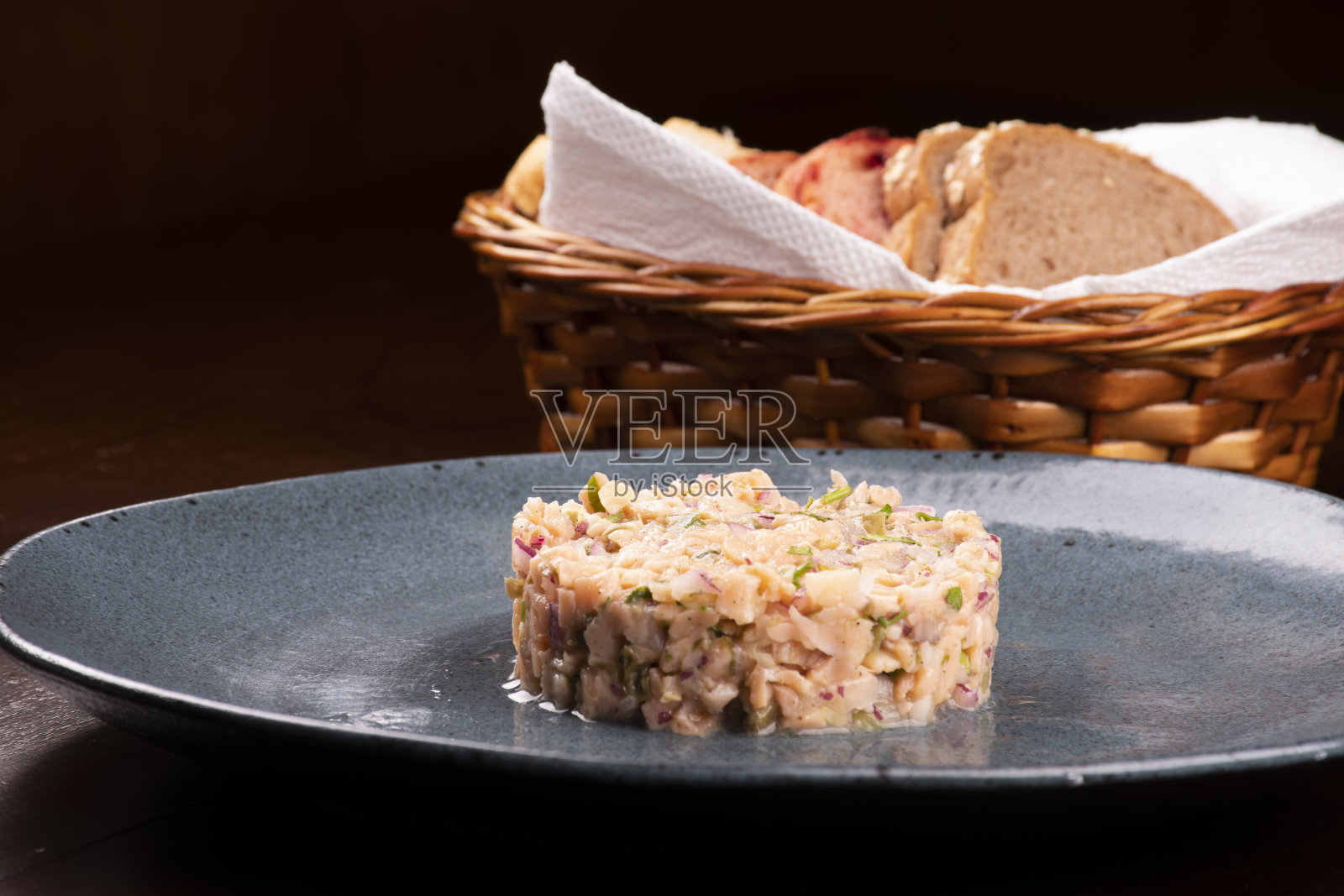 烟熏鞑靼三文鱼特写，背景是面包篮照片摄影图片