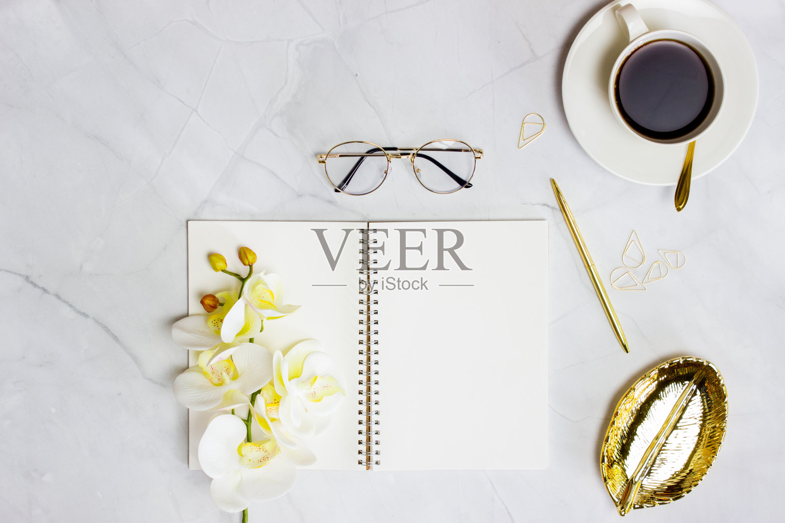 笔记本与金笔，咖啡和玻璃杯在大理石背景。照片摄影图片