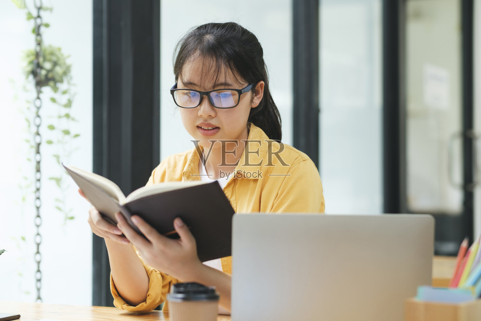 认真的年轻亚洲学生正在读书准备考试。照片摄影图片