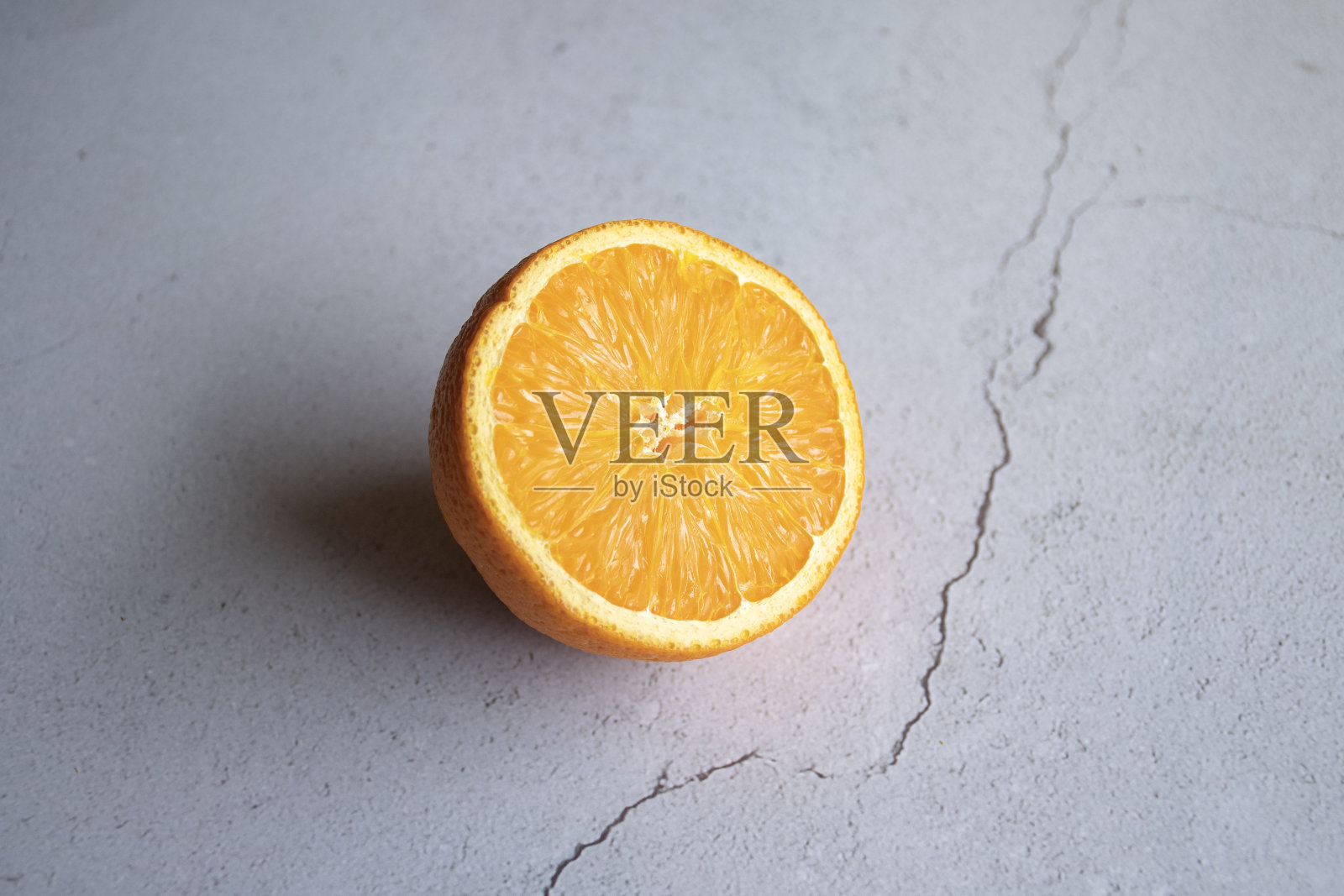 白色瓷砖背景上的半个橙色照片摄影图片