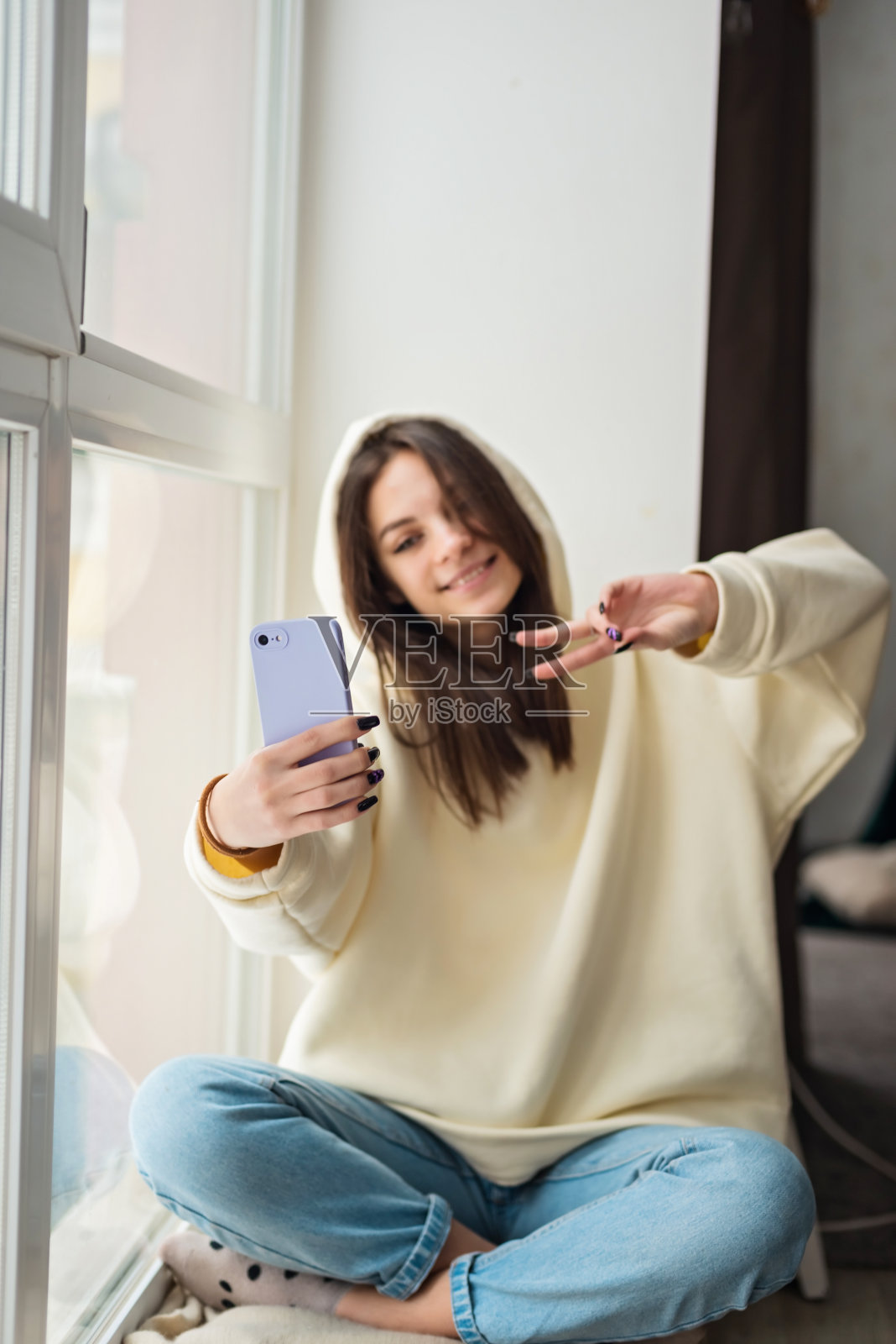 快乐的女博主用智能手机拍照自拍，用于社交媒体发布，快乐的少女通过手机与家人或朋友进行视频通话。软选择聚焦。照片摄影图片