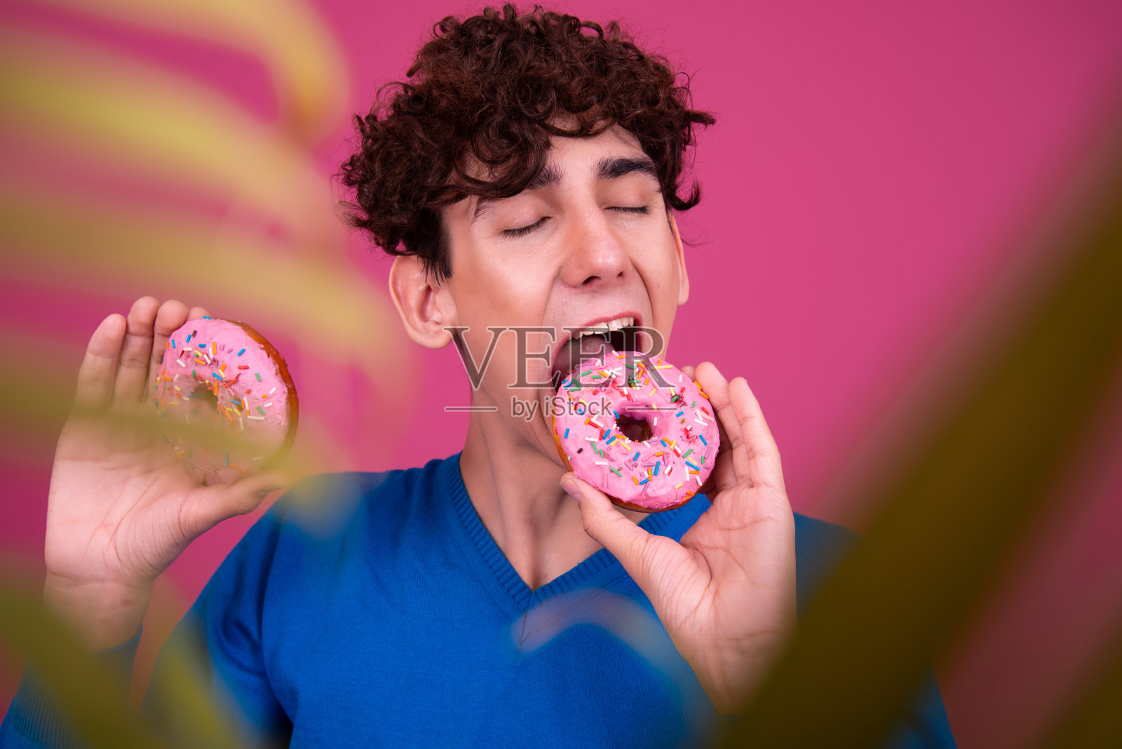 年轻的帅哥和甜甜圈。照片摄影图片