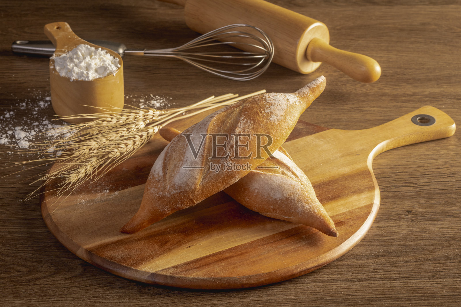 木头上放着新鲜面包和小麦照片摄影图片