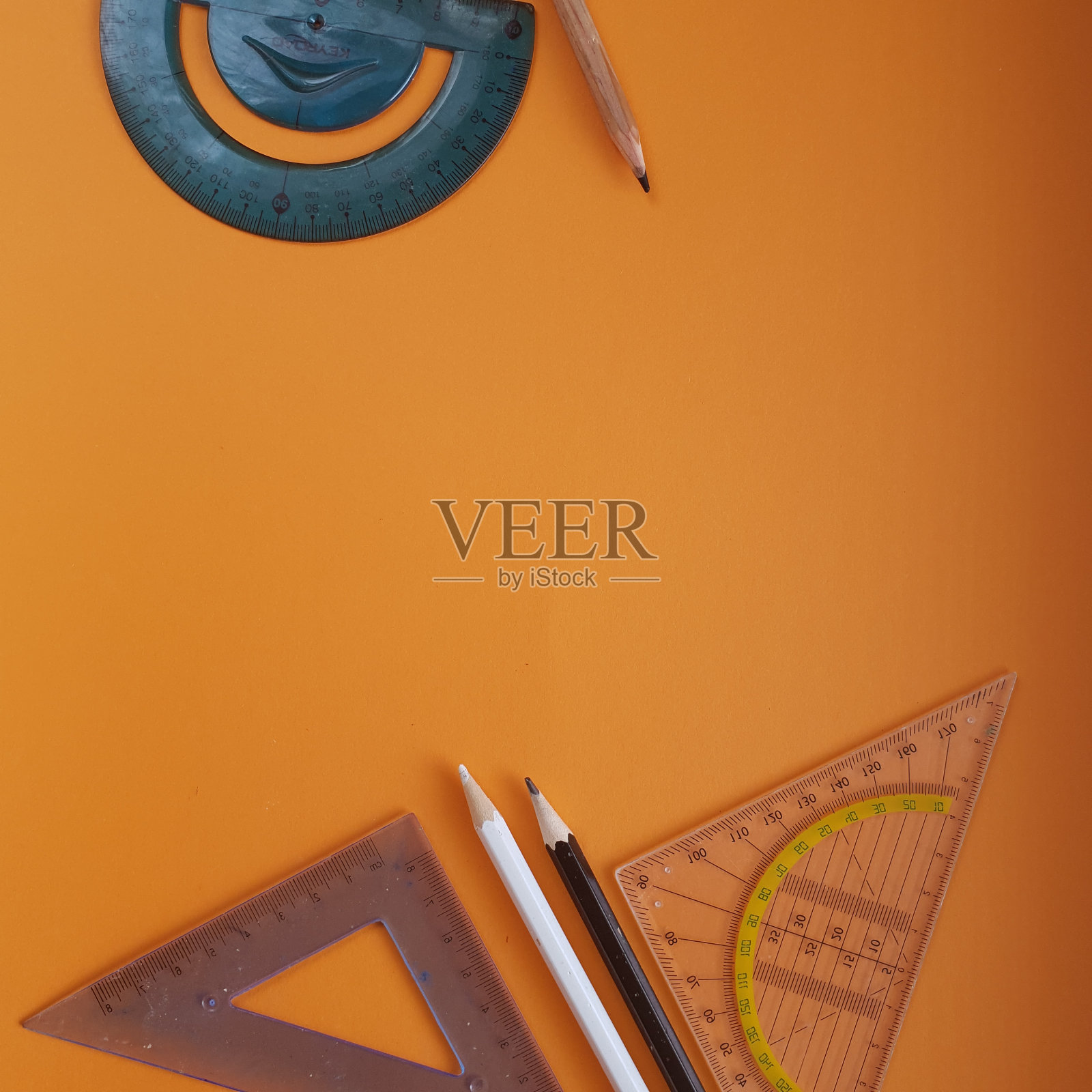 橙色背景上的彩色铅笔和尺子。办公用品、培训。照片摄影图片