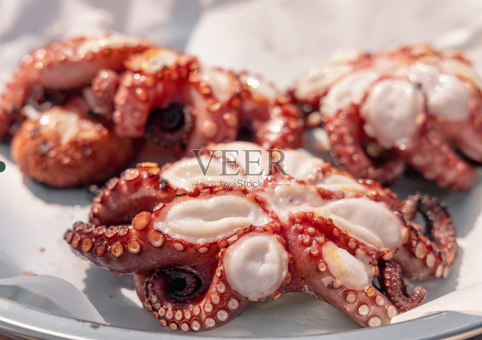 新鲜烤章鱼放在盘子里，意大利。传统的地中海式饮食。照片摄影图片