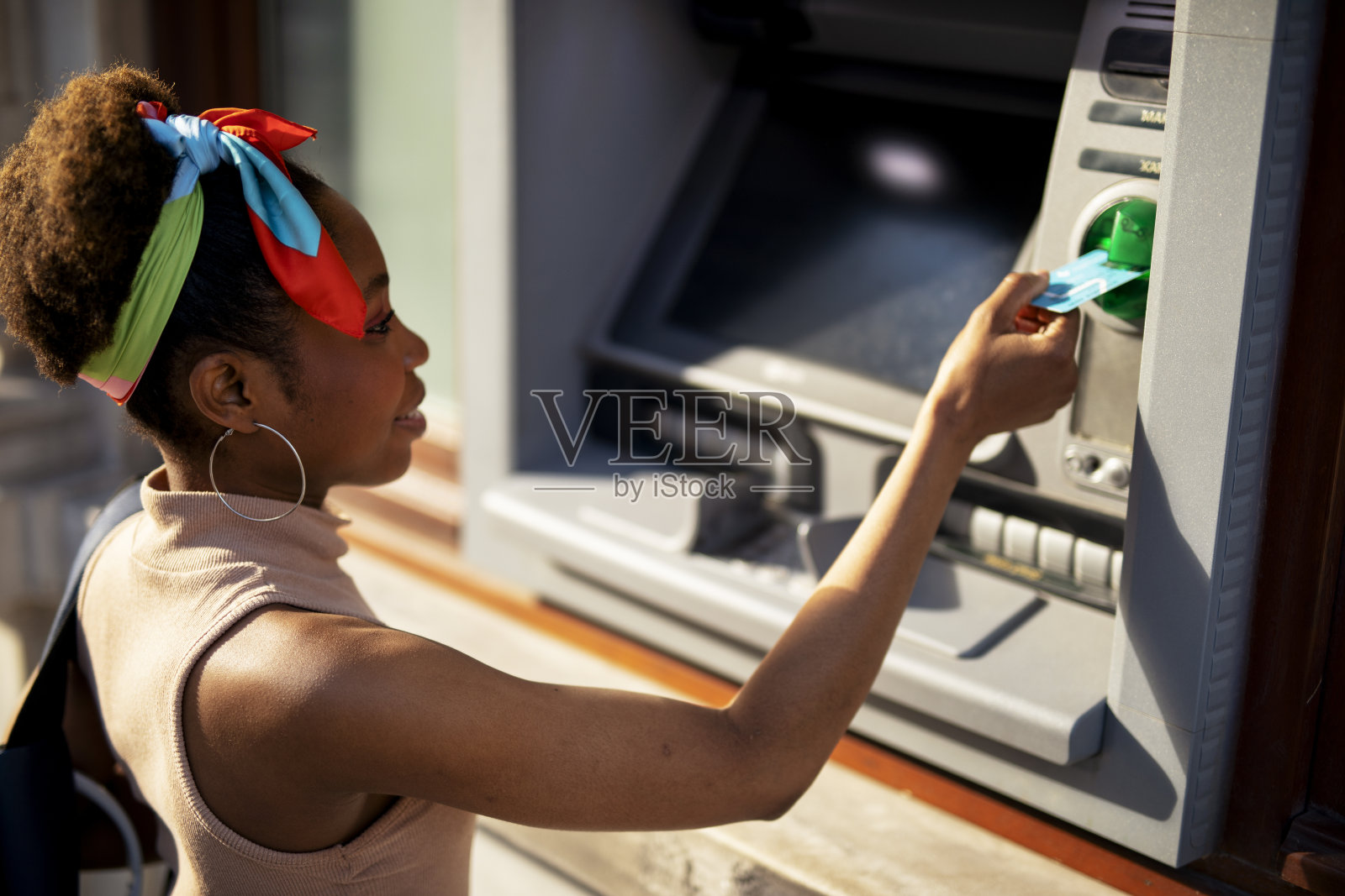 多种族妇女使用ATM机。照片摄影图片