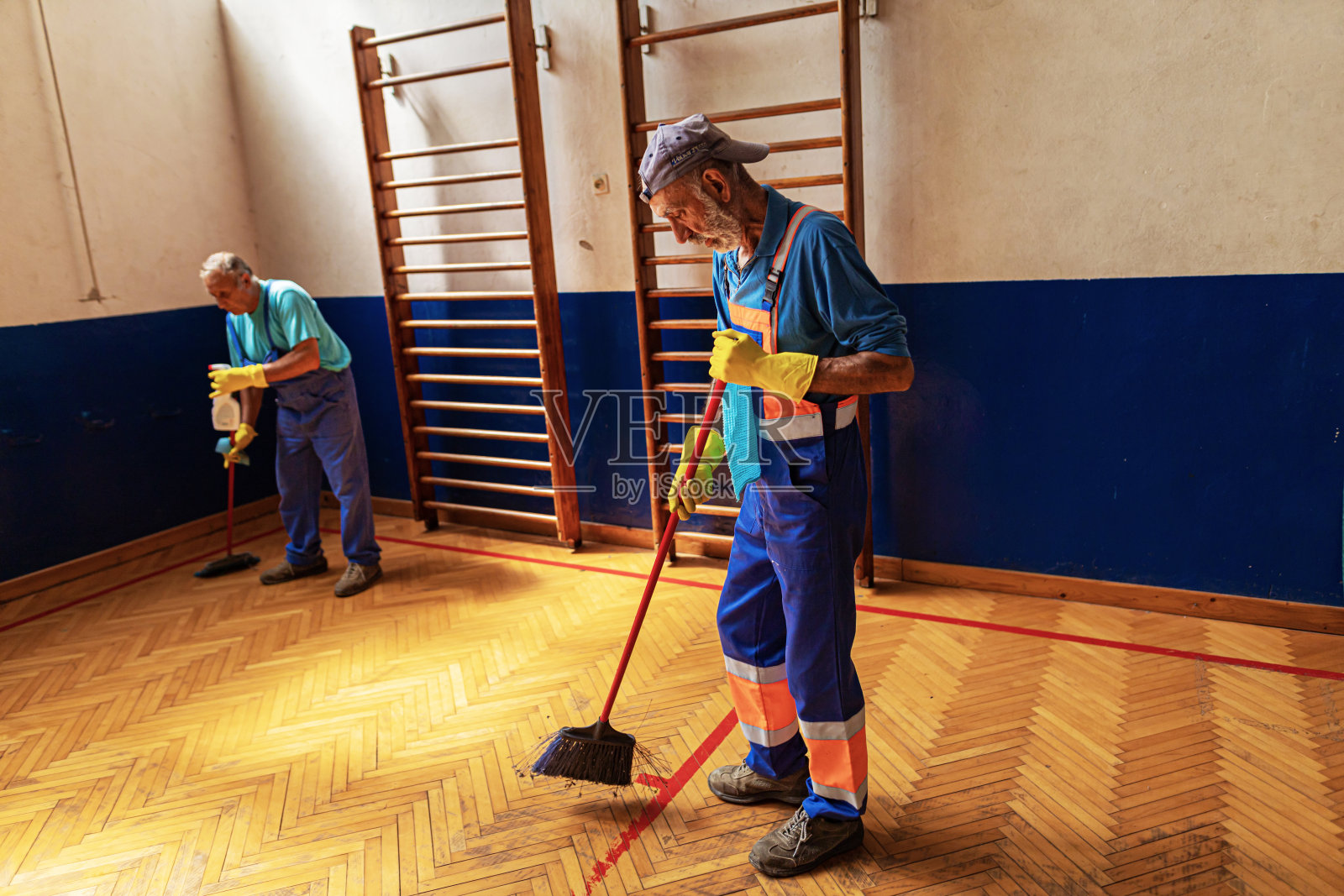 清洁工服务，两个年长的男人在打扫学校照片摄影图片