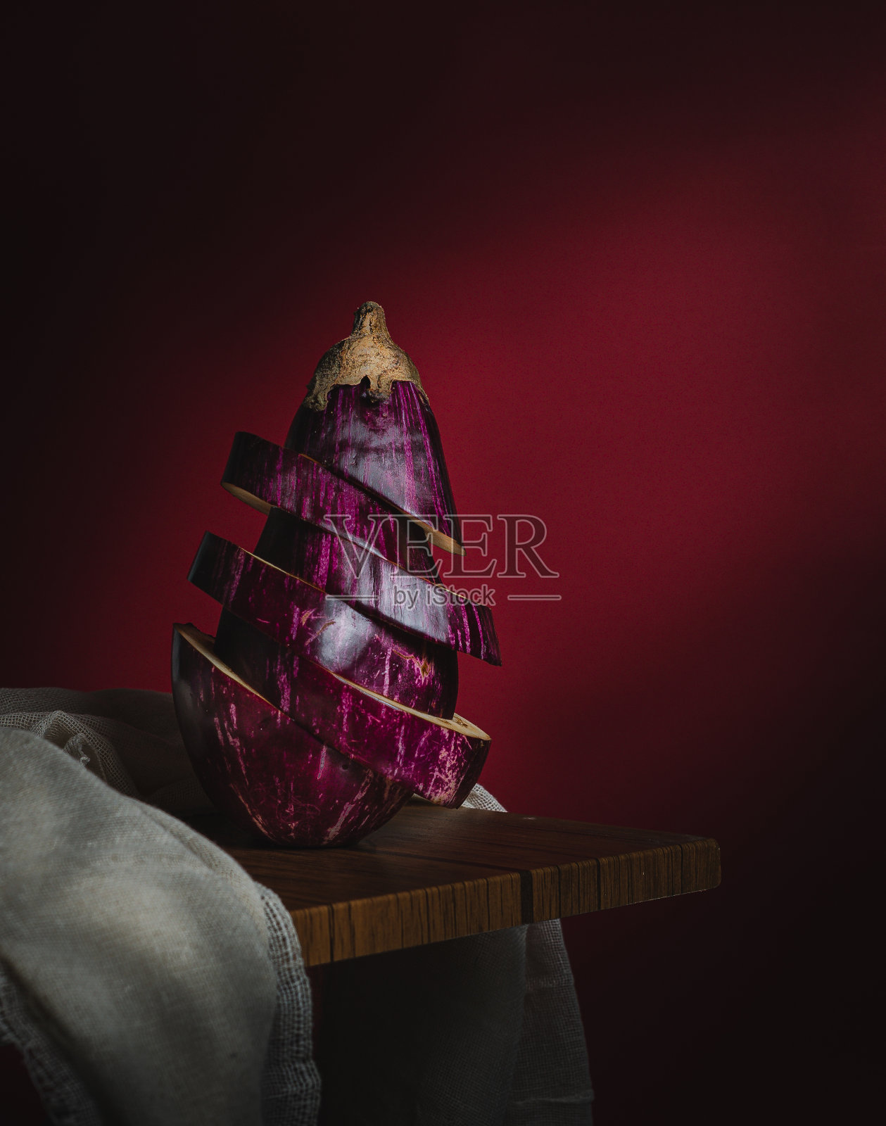 特写的条纹茄子，切片，暗红色的背景和复制空间照片摄影图片