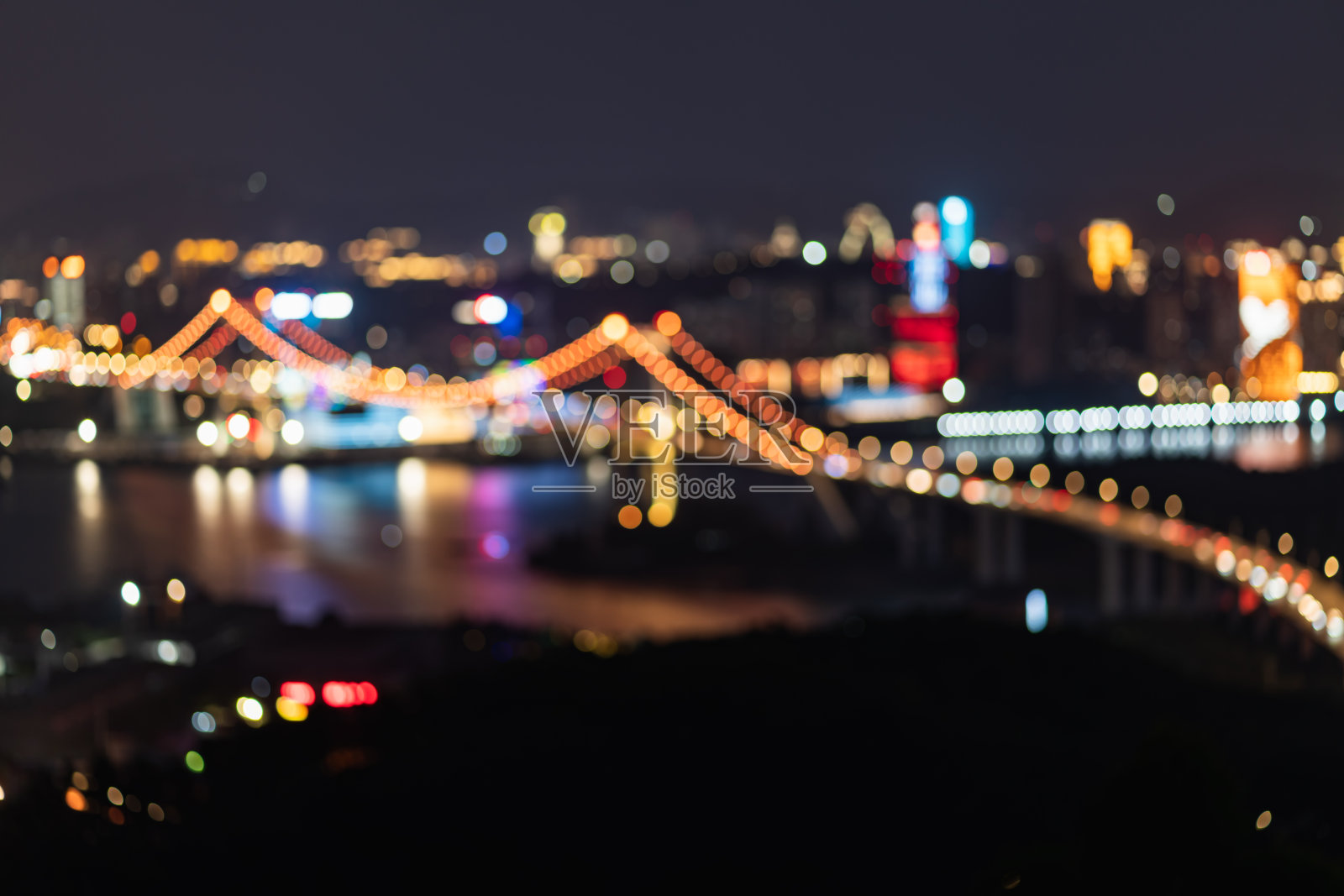 夜晚海上城市大桥的离焦灯光照片摄影图片