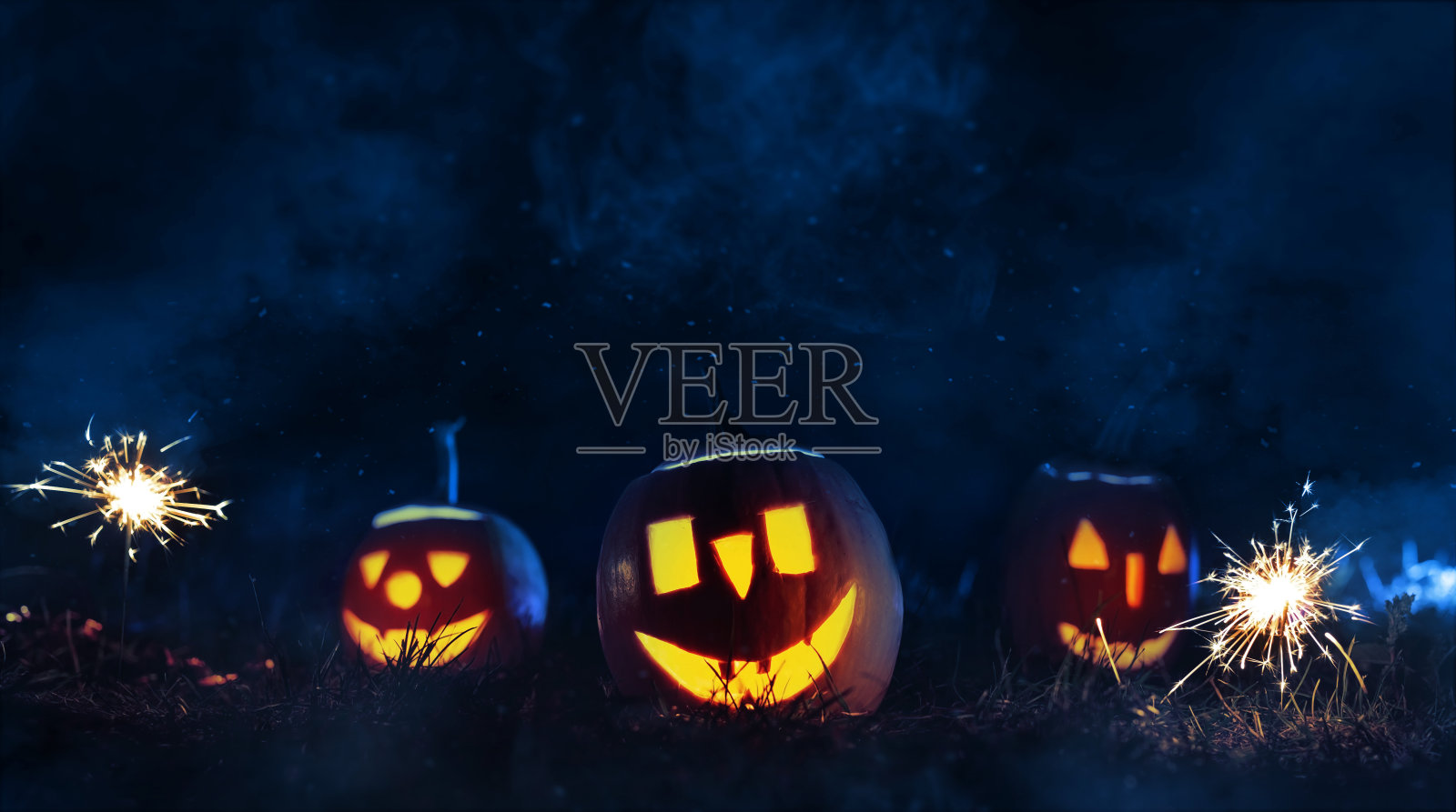 万圣节的南瓜在一个烟雾缭绕的夜晚。万圣节派对快乐。照片摄影图片