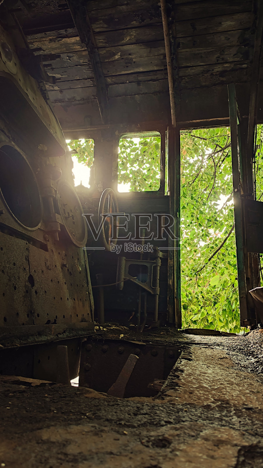 一辆废弃的老火车的内部在森林或丛林生锈的蒸汽朋克装饰-垂直的场景照片摄影图片