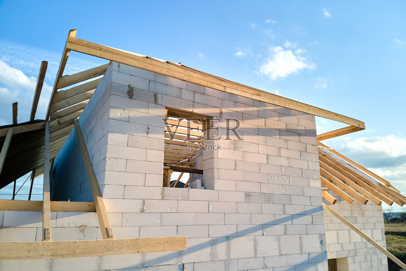 未完工的私人住宅框架鸟瞰图，带有充气轻质混凝土墙和正在施工的木质屋顶框架。照片摄影图片