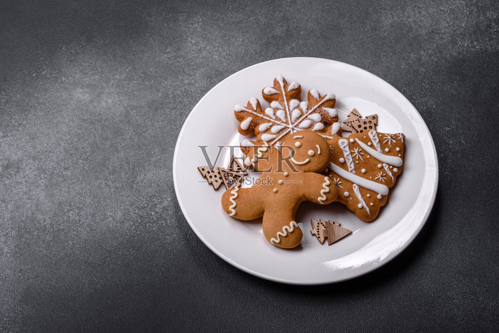 圣诞自制姜饼饼干放在深色混凝土桌上照片摄影图片