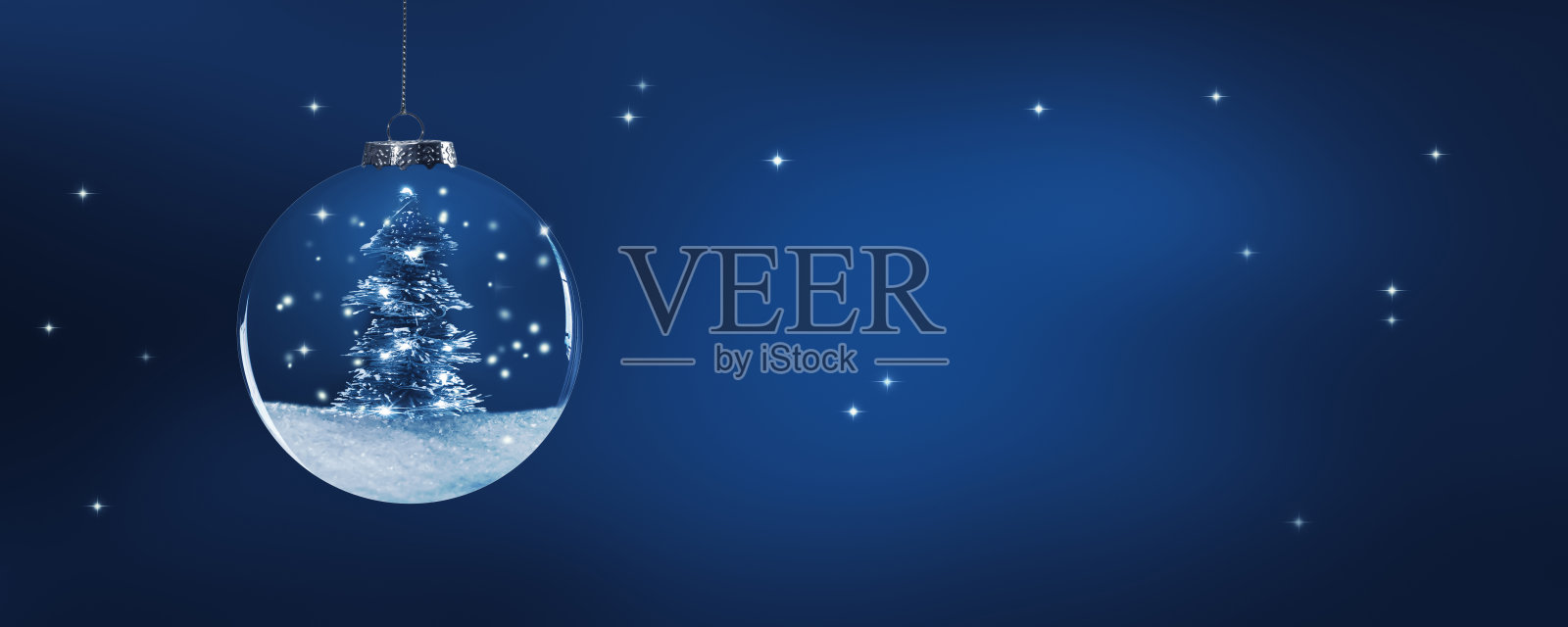 圣诞球装饰闪亮的灯在下雪的圣诞树在蓝色的夜晚，美丽的背景与火花和复制空间为新年快乐或圣诞贺卡照片摄影图片
