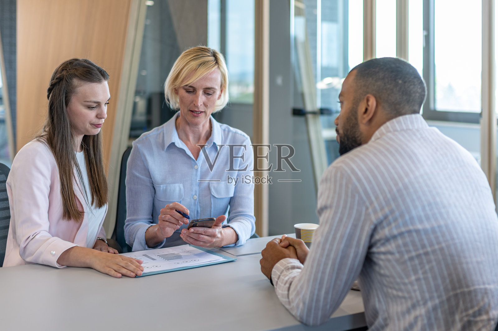 同事们在现代化的初创公司办公室和会议室讨论问题。照片摄影图片