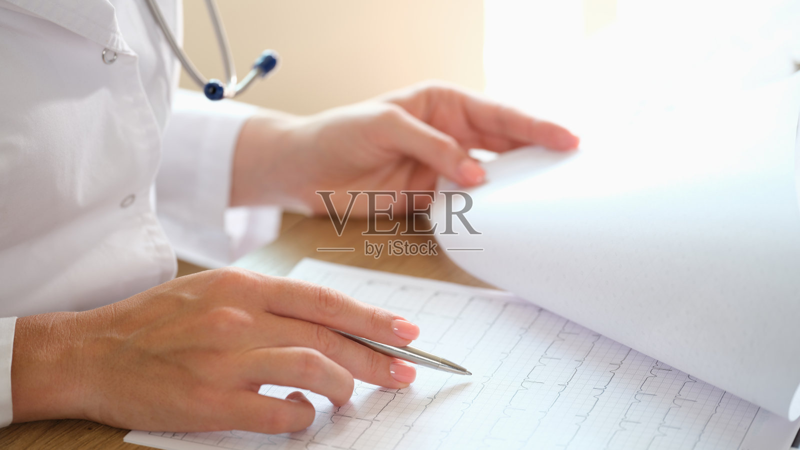 心脏病专家检查病人的心脏病和心电图照片摄影图片