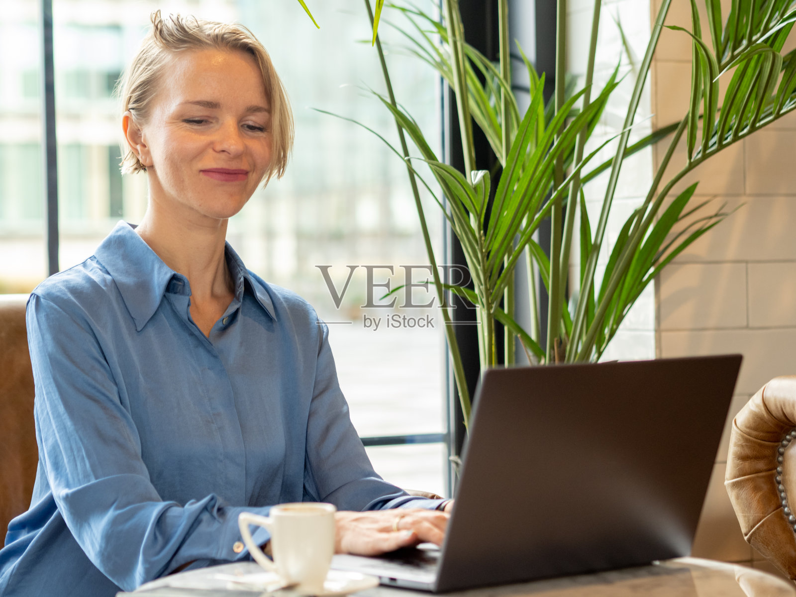 一位在咖啡店用笔记本电脑工作的女商人。新业务，女性企业家照片摄影图片