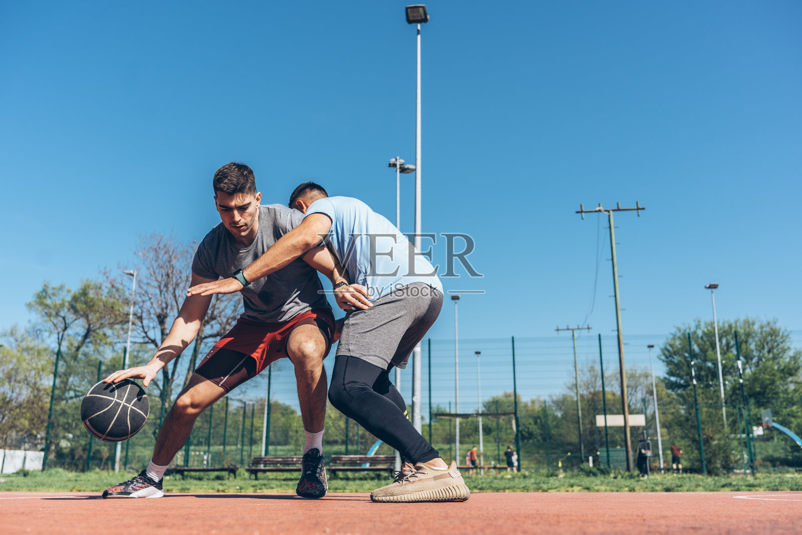 一个人挑战他的朋友去打街头篮球。照片摄影图片