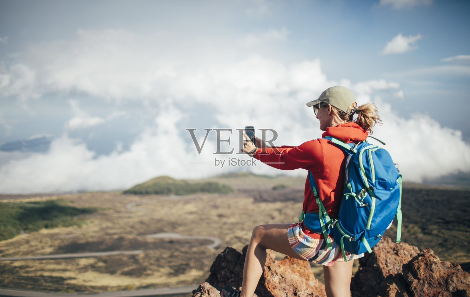 女徒步旅行者在埃特纳火山的斜坡上拍照照片摄影图片