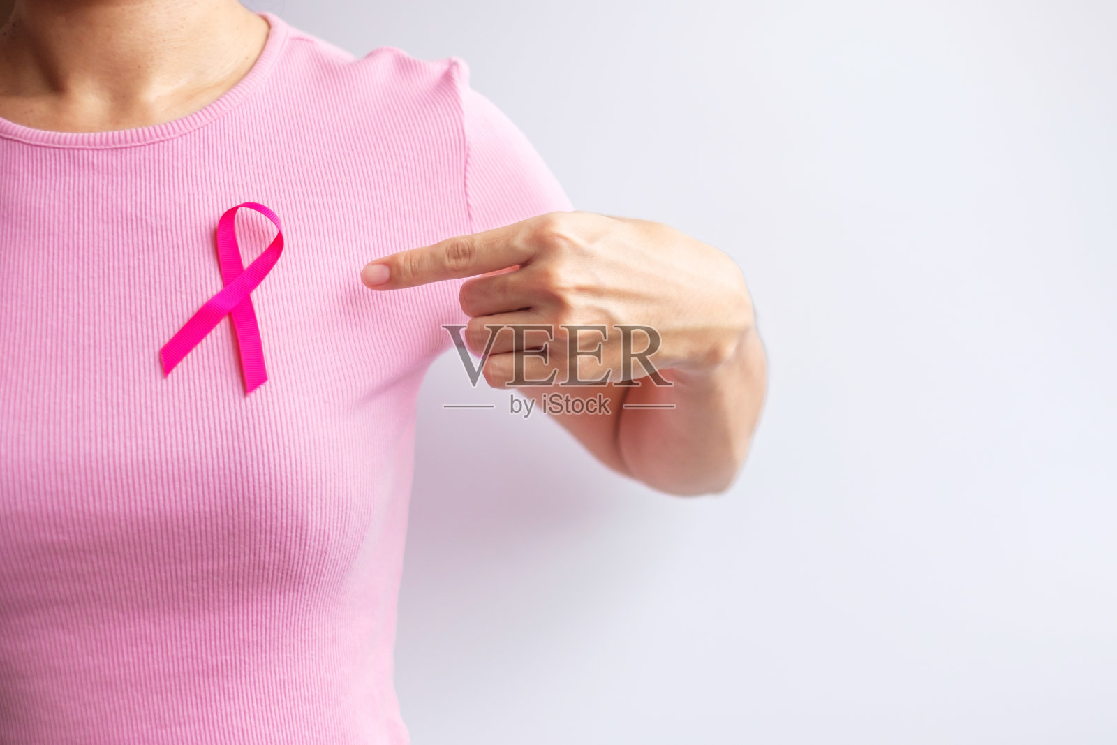 粉红十月乳腺癌宣传月，妇女手持粉红丝带，穿着衬衫，支持人们的生活和疾病。全国癌症幸存者月，母亲和世界癌症日的概念照片摄影图片