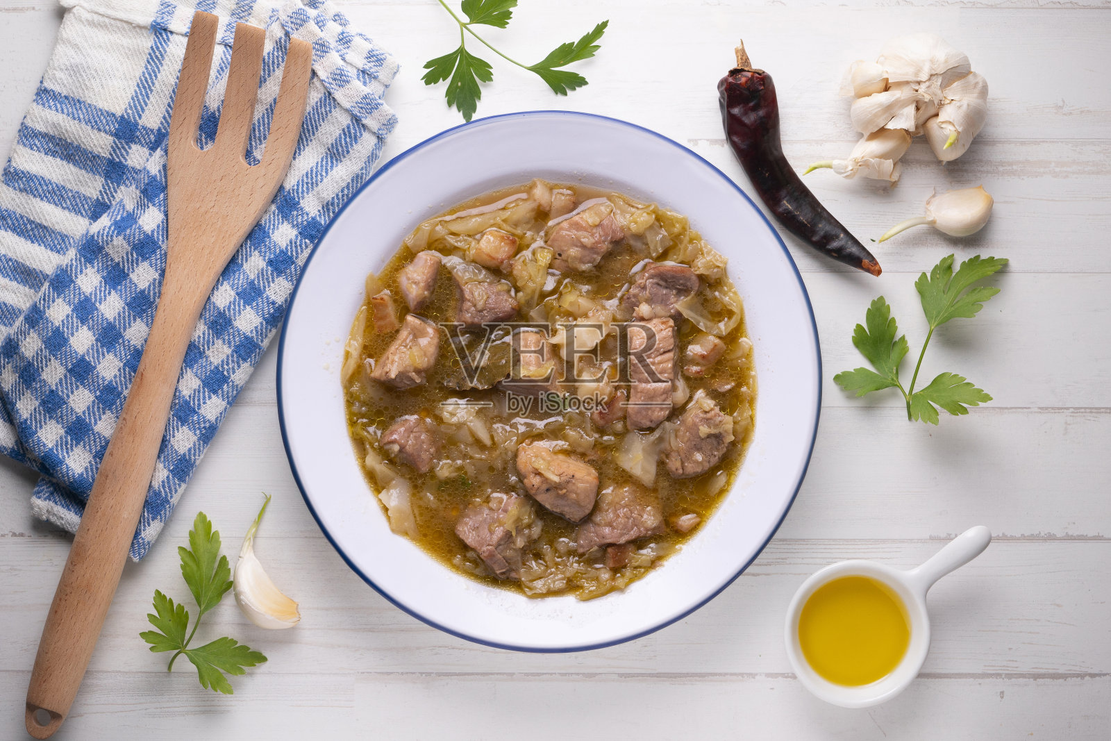 白卷心菜炖猪肉。典型的西班牙冬季食谱。照片摄影图片