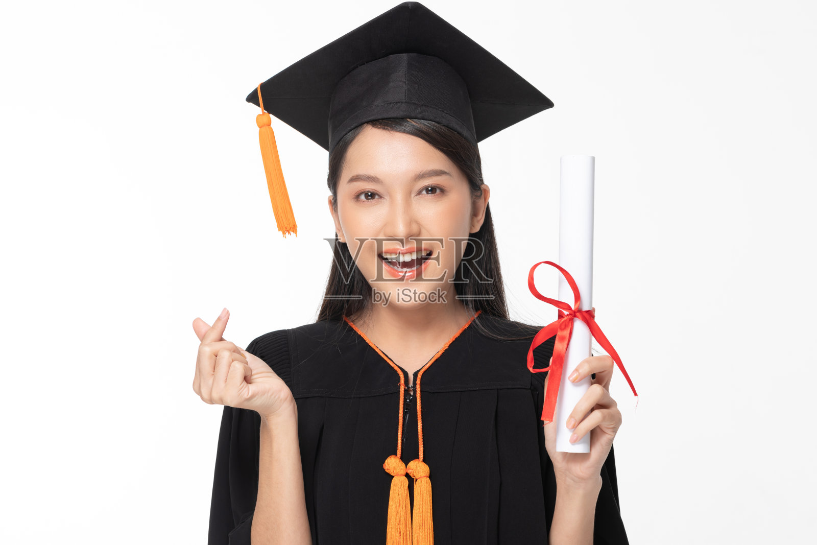 美丽迷人的亚洲女性毕业了，戴着帽子和长袍，微笑着，手里拿着证书，感到如此自豪和幸福，孤立在白色背景，教育成功的概念照片摄影图片