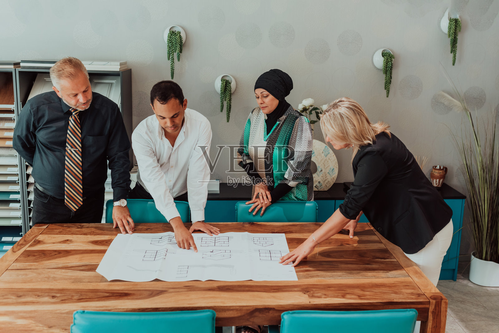 多元化团队在办公室室内的建筑项目上合作，年轻的男女创意平面设计师在头脑风暴中使用现代技术进行合作照片摄影图片