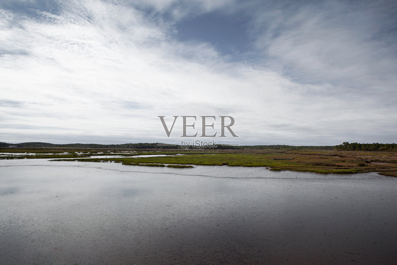 蓝蓝的天空下，低潮时的沼泽和海岸照片摄影图片